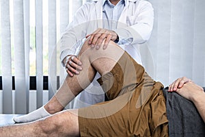 Young asian physiotherapist checking knee joint with injury to giving treatment