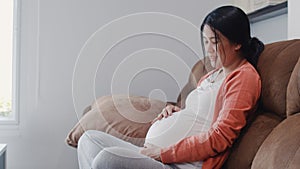 Young Asian Pregnant woman holding her belly talking with her child. Mom feeling happy smiling positive and peaceful while take