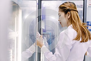 Young Asian researcher looking at the flask in the science labor