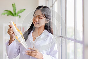 Young Asian roleplay as doctor standing happy smiling in school lab with space for text photo