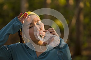 Young Asian runner girl drinking water sweaty and tired. Attractive and exhausted Korean woman thirsty after running workout and