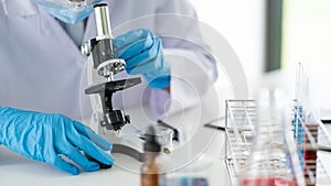 Young Asian scientist Working looking through a microscope doing research for analyzing a Experiments sample in a forensic