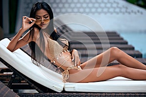 Young asian sexy girl in a beige bikini posing at hotel territory