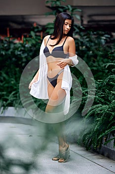 Young asian sexy girl in a white bikini posing at hotel territory