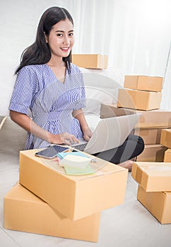 Young Asian small business owner at home office, online marketing packaging and delivery