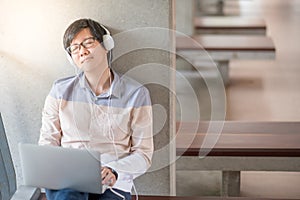 Young Asian student man enjoy listening to music