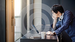 Young Asian student man with laptop computer