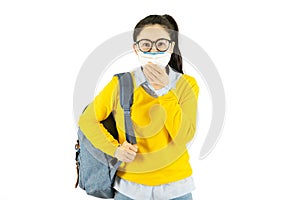 Young asian student woman in glasses wearing medical face mask,carrying a bag to go to school Under the outbreak of the virus