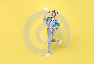 Young Asian student woman shouting into megaphone making announcement in isolated on yellow background