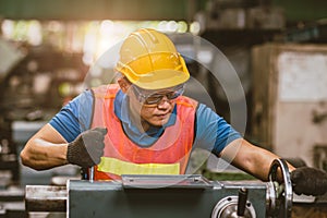 Young Asian Technician Engineer Staff Worker using Lathe CNC Milling Machine work in Heavy Metal Factory