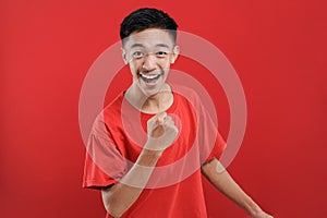 Young Asian teenager doing winning gesture, Happy get special gift