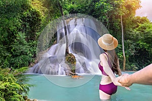 Young Asian tourists swim at Kaew Mongkhon Waterfall. Close to Kuang Si Waterfall