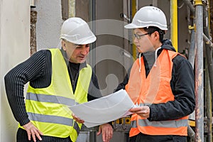 Asian apprentice engineer at work on construction site with the senior manager