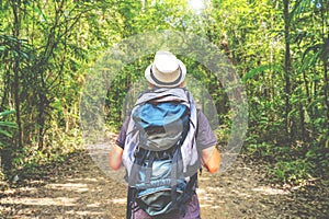 Young asian travel man standing alone in forest outdoor with sunlight nature on background, Travel Lifestyle and survival concept