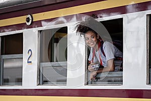 Young asian travel by train sticking her head out of the train, Happy smiling woman female girl looks out from train