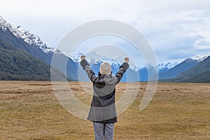 Young Asian traveler celebrating success at Eglinton Valley, Te anua, South Island, New Zealand
