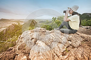 Young Asian traveler woman looking a binoculars.