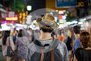 Young Asian traveling backpacker in Khaosan Road night market in evening in Bangkok, Thailand. photo