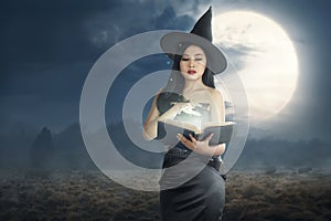 Young asian witch woman reading the spell books