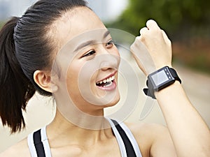 Young asian woman answering a call using wearable device