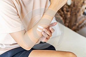 Young asian woman applying arm cream, lotion. Young Female do daily beauty body procedures or treatment. Hygiene and skin care