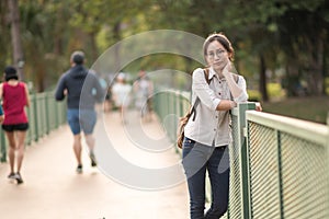 Young Asian woman with backpack standing and looking for someth