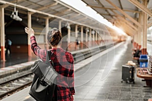 Young Asian woman backpacker traveler walking alone at train station platform with backpack. Asian woman waiting train