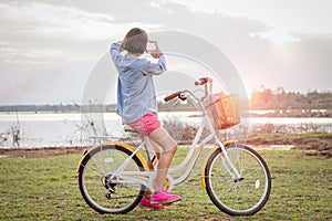 young asian woman on bicycle look at hand frame view