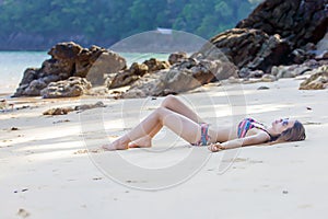 Young Asian woman in bikini relaxing on the beach,Travel summer vacation concept.