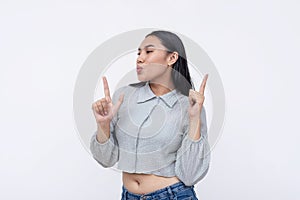 A young asian woman blows her finger guns. Isolated on a white background