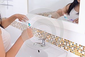 Young asian woman brush the teeth in bathroom after wake up in morning