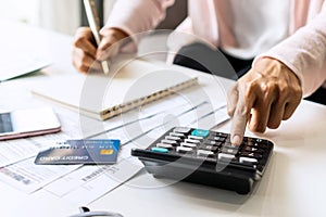 Young Asian woman Calculating monthly expense at her desk. Home saving concept. Financial and Installment payment concept.