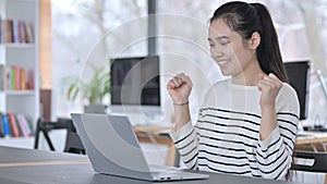 Young Asian Woman Celebrating on Laptop in Library