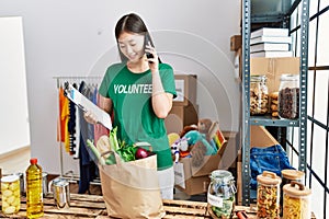 Young asian woman checking donated food on the phone at donations stand