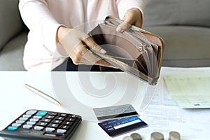 Young Asian woman checking her wallet to calculating monthly expense at her desk. Home saving concept. Financial and Installment