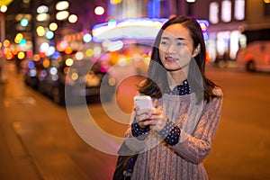 Young Asian woman in city at night