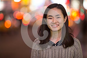 Young Asian woman in city at night