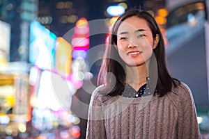 Young Asian woman in city at night