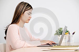 Young asian woman concentrate on working with laptop computer at home office, Asia office female comtemplate on working with