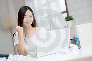 Young asian woman confident working at home with laptop computer and thinking idea for planning.