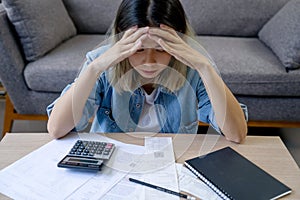 Young asian woman cover her head after stressed with monthly bill expenses and credit card debt