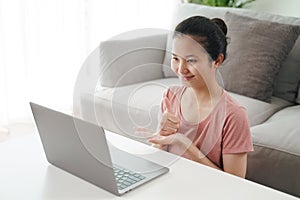 Young Asian woman deaf disabled using laptop computer for online video conference call learning and communicating in sign language