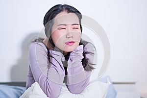 Young Asian woman depressed - young beautiful and sad  Chinese girl on bed with pillow feeling unhappy and broken heart suffering