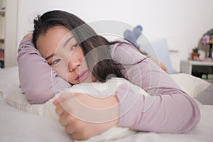 Young Asian woman depressed - young beautiful and sad  Chinese girl on bed with pillow feeling unhappy and broken heart suffering