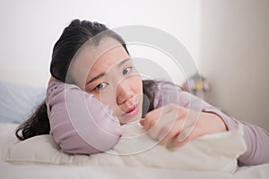 Young Asian woman depressed - young beautiful and sad  Chinese girl on bed with pillow feeling unhappy and broken heart suffering