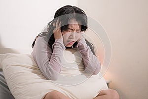 Young Asian woman depressed - young beautiful and sad  Japanese girl on bed with pillow feeling unhappy and broken heart suffering