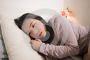 Young Asian woman depressed - young beautiful and sad  Japanese girl on bed with pillow feeling unhappy and broken heart suffering