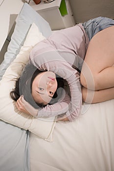 Young Asian woman depressed - young beautiful and sad  Japanese girl on bed with pillow feeling unhappy and broken heart suffering