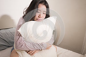 Young Asian woman depressed - young beautiful and sad  Japanese girl on bed with pillow feeling unhappy and broken heart suffering