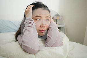 Young Asian woman depressed - young beautiful and sad  Japanese girl on bed with pillow feeling unhappy and broken heart suffering